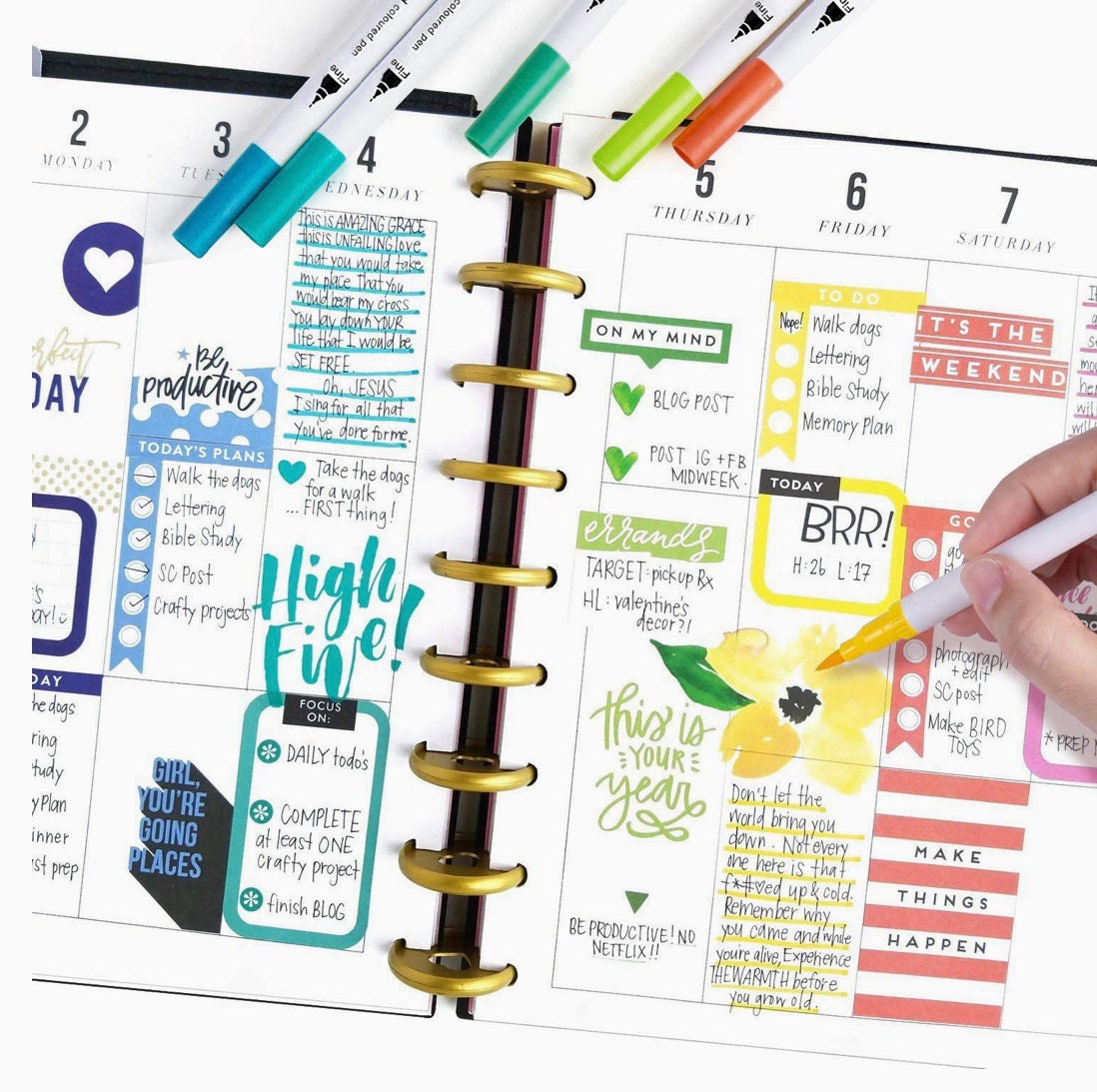 12-Color Dual Tip Brush Pens being used to create colorful designs and calligraphy in a planner.