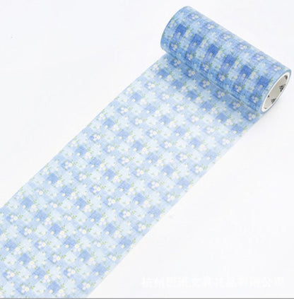 Floral Blue Washi Tape with white flowers and green leaves, unrolled, for crafting and DIY projects.