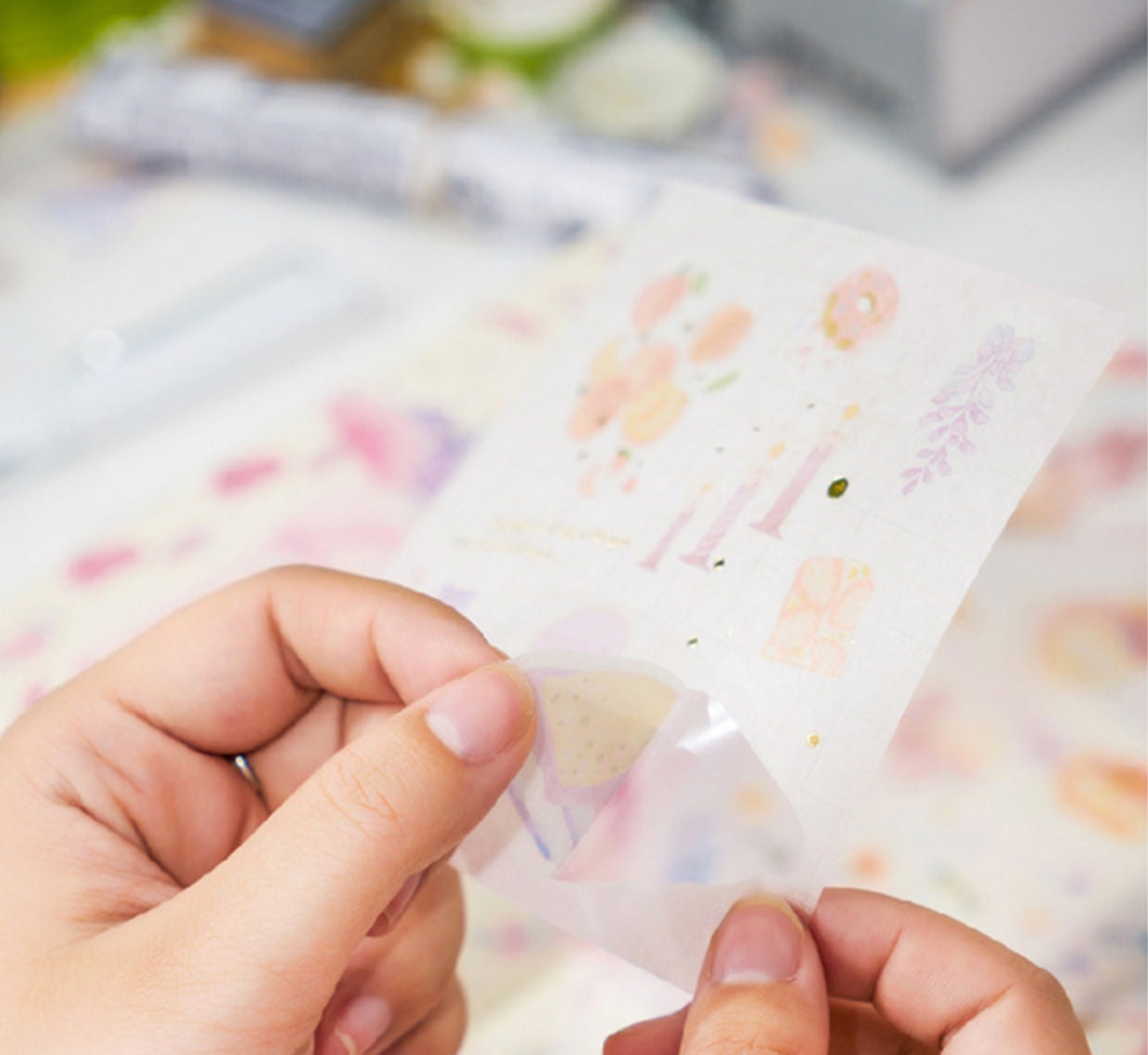 Close-up of hands peeling a colorful sticker from the Red Fruit Washi Tape Set, perfect for bullet journal decoration.