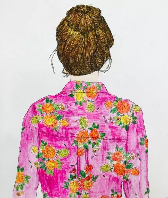 Illustration from Traveling Paris Coloring Book featuring a girl with a bun hairstyle wearing a pink floral shirt.