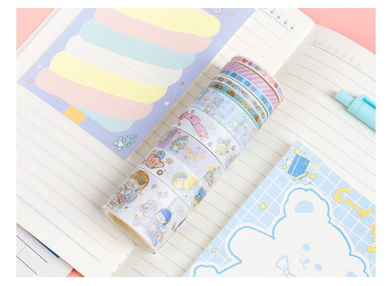 Blue Candy Washi Tape Set of 10 rolls with mixed widths, featuring cute kawaii designs displayed on an open notebook with pastel-colored notepad and blue pen.