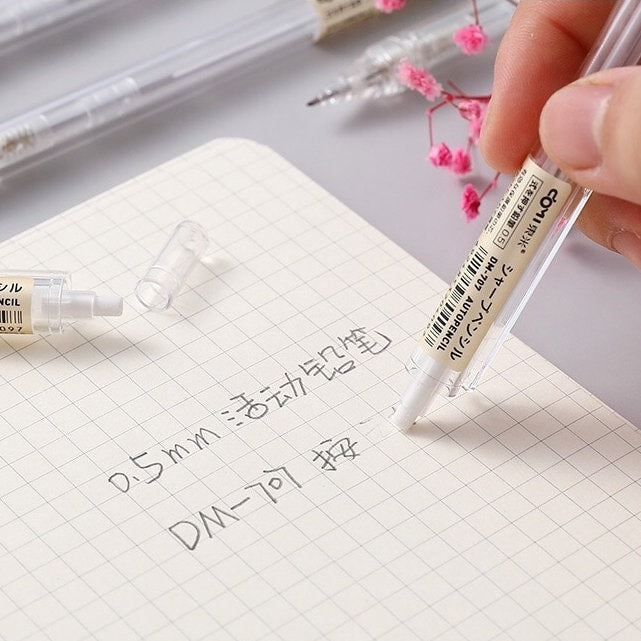 0.5mm transparent mechanical pencil writing on grid paper, perfect for office and student stationery needs.