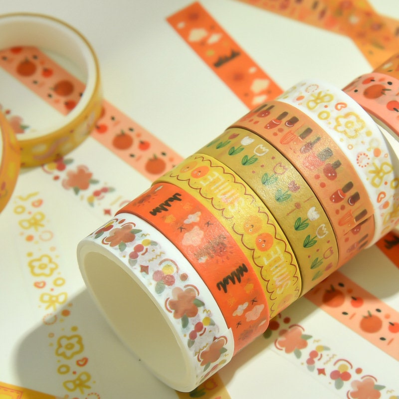 Cute colorful washi tape set with 5 rolls featuring adorable kawaii designs in orange, yellow, and floral patterns, perfect for DIY crafts and journaling.