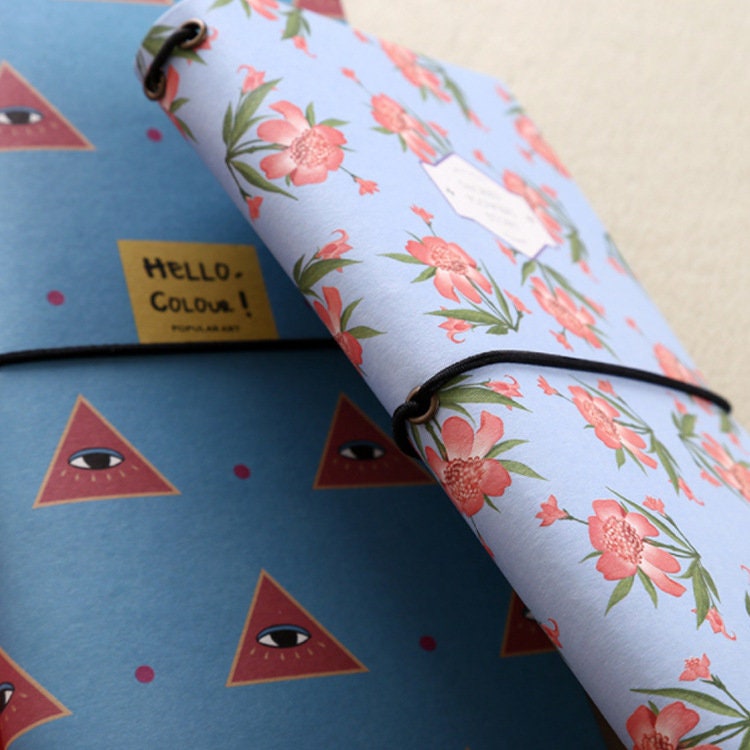 Spring Flower Kraft Journals in Recycled Paper Set featuring pastel blue covers with pink floral designs, secured with black elastic bands, eco-friendly stationery.