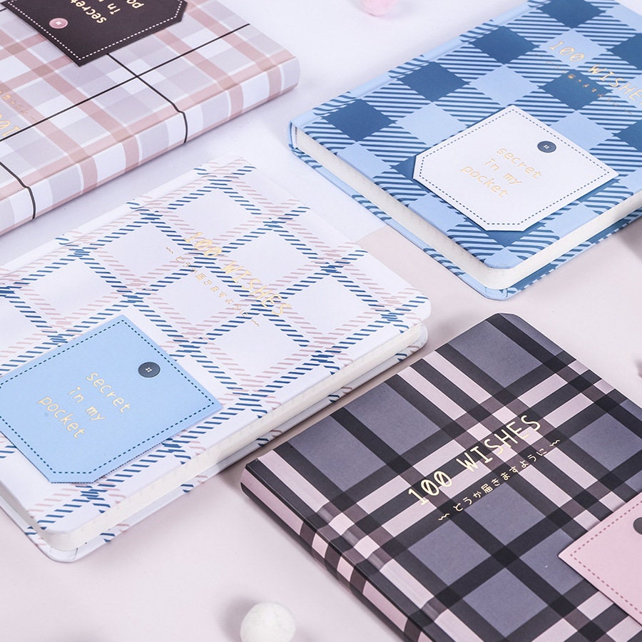 Hard Cover A5 Minimalist Grid Pocket Planner with stylish plaid designs in pastel and blue colors, neatly laid out on a white surface, perfect for organizing and planning. Ideal for stationery lovers and daily use.