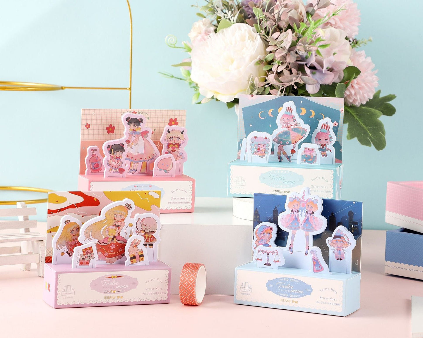 Twelve Moon Sticky Notes & Washi Tape Set featuring whimsical kawaii designs with characters in various outfits; includes pastel-colored memo pads and decorative washi tape in a beautifully arranged setting with floral background.