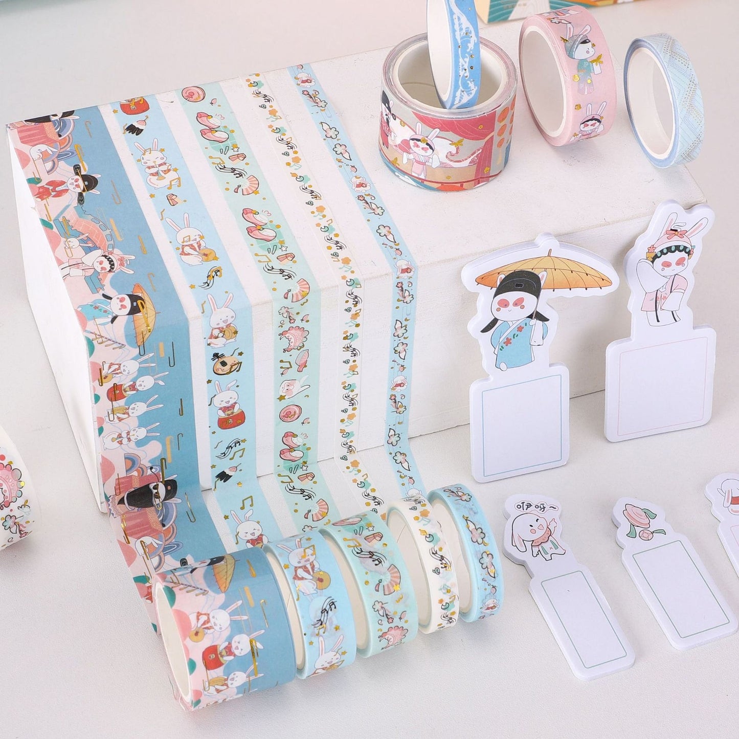 Cute Rabbit Sticky Notes and Washi Tape Set featuring colorful, kawaii-style rabbit illustrations on sticky notes and decorative Washi tape rolls in blue, pink, and white. Ideal for scrapbooking, journaling, and cute stationery collections.