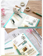 Cute Colorful Washi Tape Set - 5 Rolls, 5 Meters displayed with decorative designs on an open notebook, accompanied by a green fountain pen and pink dried flowers.