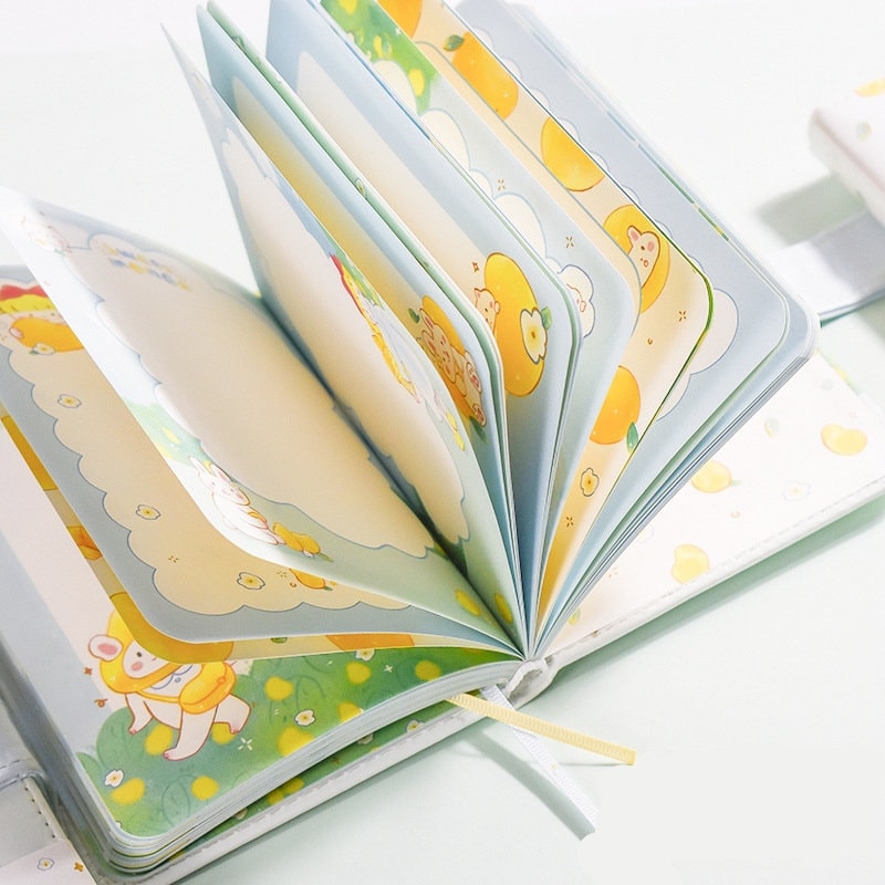 Magnetic Buckle Leather Planner with Lemon Girl Design, open to reveal cute and colorful illustrated pages with lemon and character motifs. Kawaii stationery for organized planning.