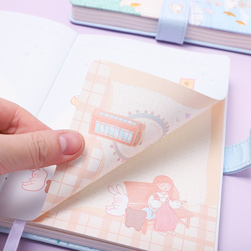 Close-up view of Cute Pink Leather Animal Town Journal - A5 Magnetic featuring adorable animal-themed and doll illustrations on the pages.