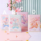 Fantasia in F Minor Journal - Leather Cover & Bookmark in four designs, A, B, C, and D, displayed against a pastel backdrop with pink flowers, featuring kawaii style illustrations and a secure clasp.