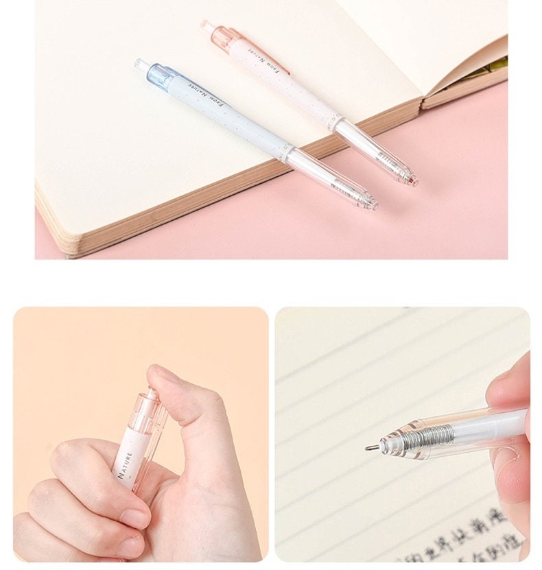 Minimalist 0.5mm black ink gel pens in pastel blue and pink placed on an open notebook, detailed view of the pen tip and a person holding the pen. Ideal for office and student use.