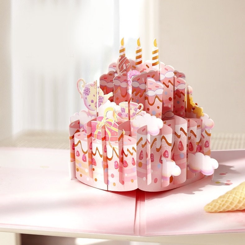 3D pink cake pop up card with intricate birthday design, featuring layered cake tiers, candles, and decorative elements in kawaii style.