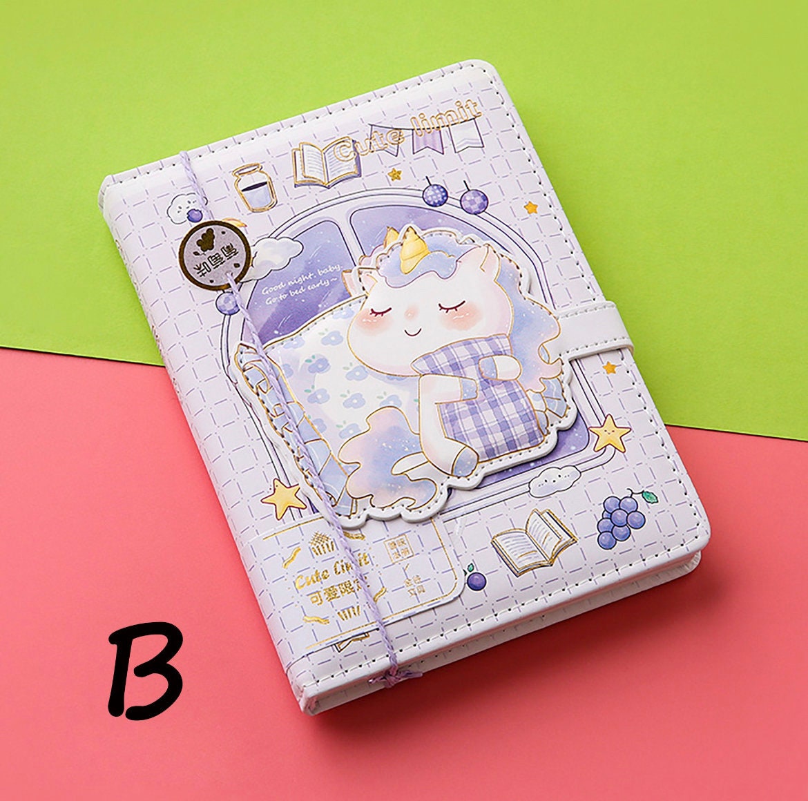 A5 leather journal with a cute anime-style animal design and attached bookmark, featuring a pastel sleeping unicorn with decorative elements on a green and pink background