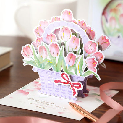 3D Pink Flower Pop-Up Greeting Card - Rose & Lily with delicate pink tulips in a lavender basket adorned with a red bow, perfect for birthdays, anniversaries, and special occasions.