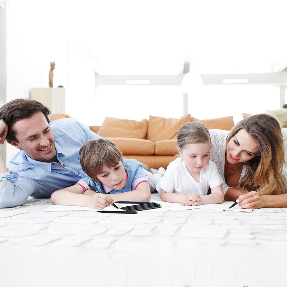 Family enjoying 36-color fineliner pens set for journaling and drawing, parents and children creating colorful artwork on a cozy carpet.