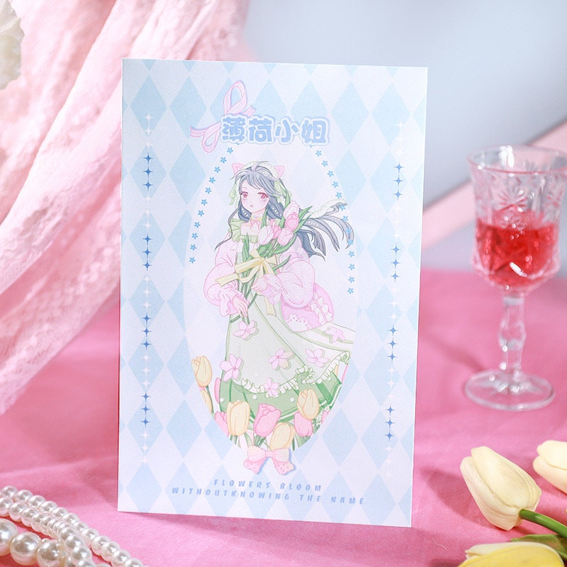 3D Flower and Butterfly Pop-Up Greeting Card featuring a pastel-colored illustration of a girl with flowers, surrounded by diamond pattern accents, on a pink fabric background with tulips and pearl necklace.