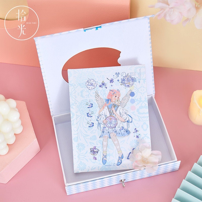 Dream Concerto Hard Cover Journal with Locker - A6, featuring a delicate kawaii illustration of a fairy girl with pink hair and wings, surrounded by pastel butterflies and flowers, in an elegant gift box.