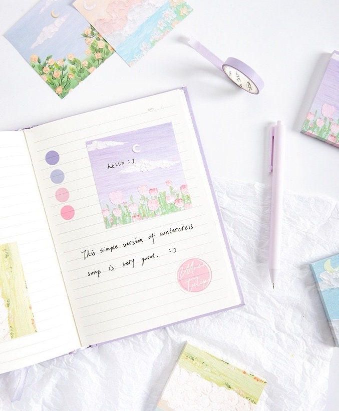 Flower Field Sticky Notes Set - 120 Pieces featuring colorful, floral-themed sticky notes in a planner, next to a lavender pen and decorative tape on a white background.