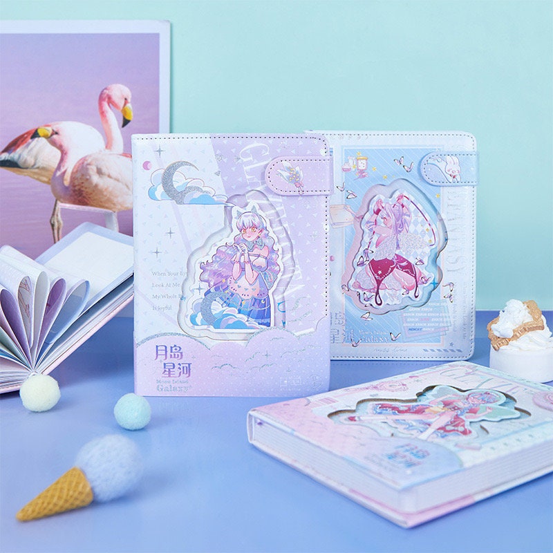 Pink Leather Galaxy Planner with Magnetic Buckle featuring cute anime-style illustrations, surrounded by pastel-colored decorative items on a desk.