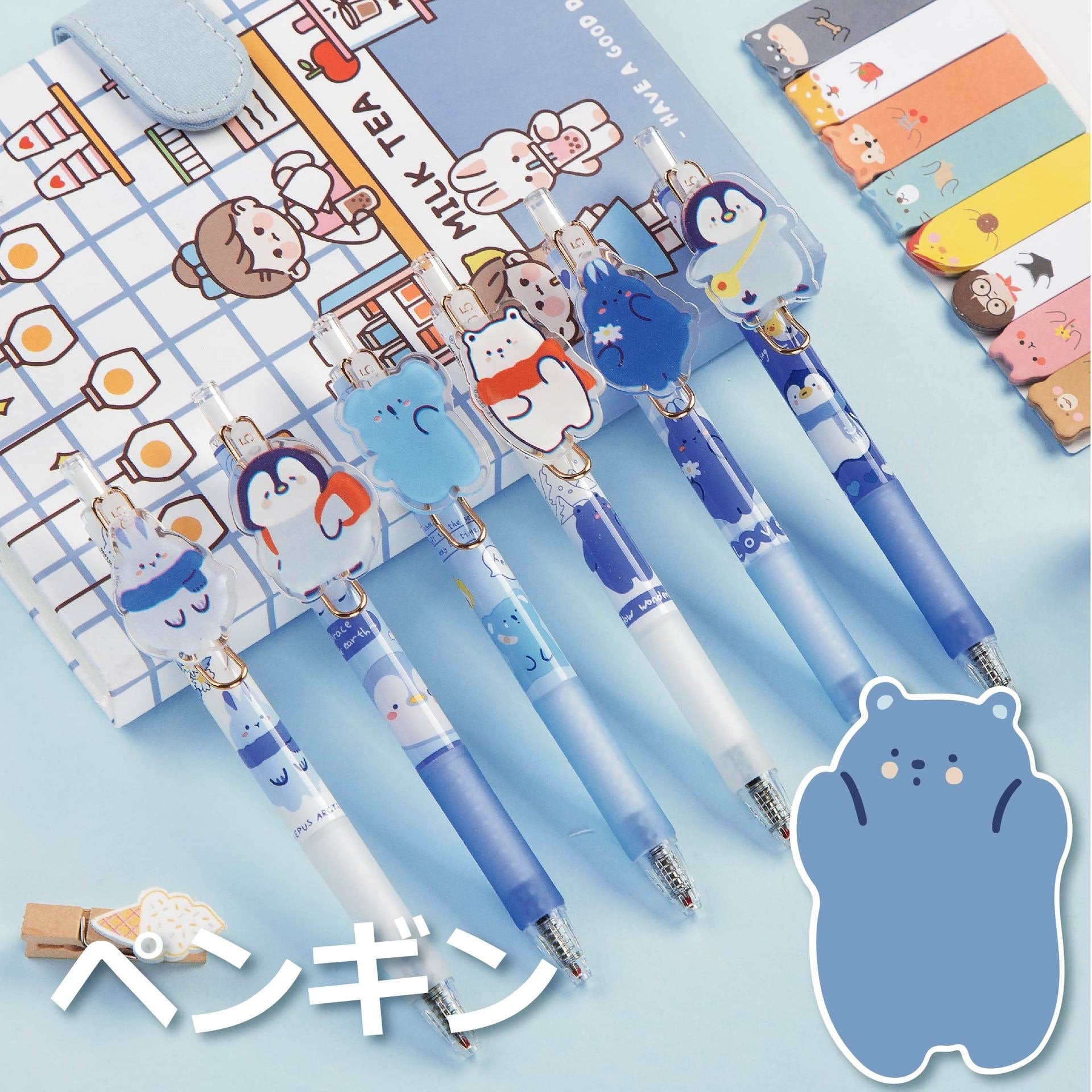 Love the Earth Gel Pen - 0.5mm Micro Point with adorable penguin designs in a kawaii style, displayed with cute animal-themed bookmarks and a colorful notebook.