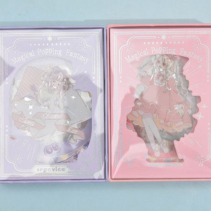 Magical silver foil stickers for planners and crafts featuring adorable kawaii characters in pastel-themed boxes, including one box in purple with a seated character and another in pink with a standing character, titled "Magical Popping Fantasy."