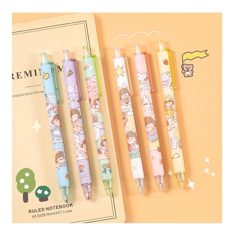 Kawaii Girl Gel Pen Set - 0.5mm Black Ink featuring six colorful pens with adorable girl and animal designs, placed on a beige ruled notebook with kawaii illustrations on an orange background.