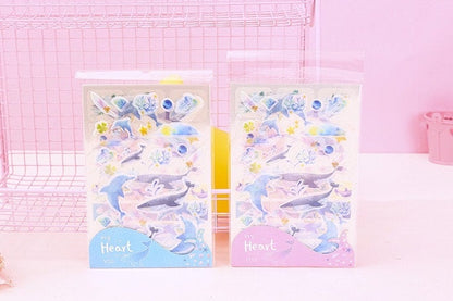 Kawaii Dolphin Ocean Stickers Set with 20 adorable dolphin designs in pastel colors, featuring playful dolphins, ocean waves, and seashells, perfect for decorating planners, notebooks, and scrapbooks.