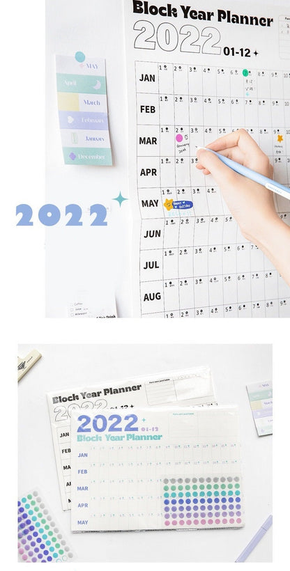 2022 Yearly Planner - Goal Tracker and Organizer with colorful stickers for each month, featuring a hand writing on the planner, designed for effective planning and productivity.