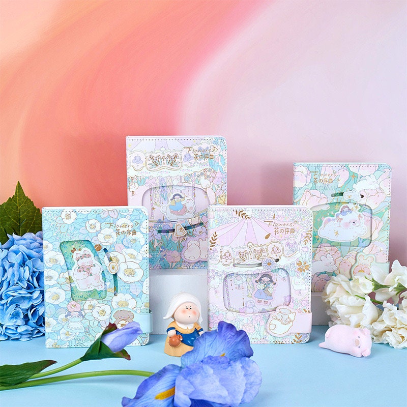 Flower Prelude Pink Leather Planner with Magnetic Buckle, featuring kawaii floral designs displayed alongside blue and white hydrangeas and decorative figurines.