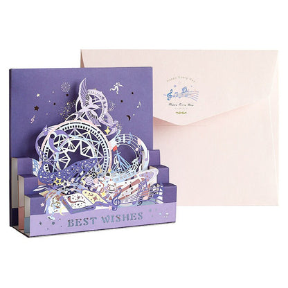 Starlight Studio Pop Up 3D Greeting Card, purple greeting card with intricate celestial designs, musical notes, stars, and "Best Wishes" text, accompanied by a matching envelope.