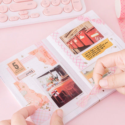 Colorful Grid Washi Tape Set in use on a planner with hands placing pink grid pattern tape, surrounded by cute stationary and photos.