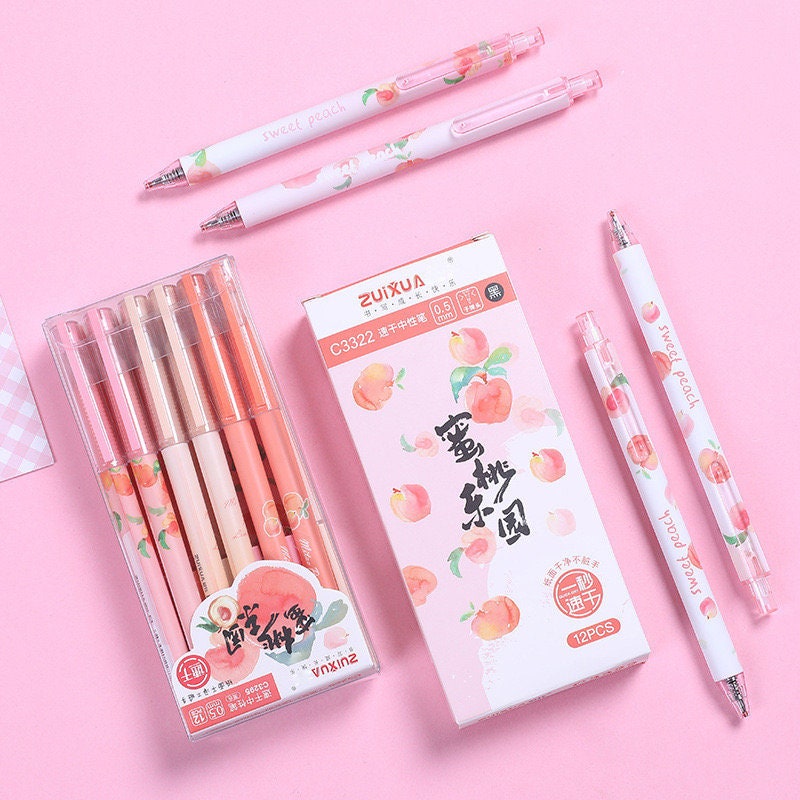 Peach Scented 0.5mm Kawaii Gel Pen with peach-themed designs on a pink background, featuring a set of six pens in various shades of pink and peach packaging.