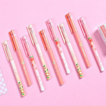 Peach Scented 0.5mm Kawaii Gel Pens with pastel pink and peach designs laid out on a pink background.