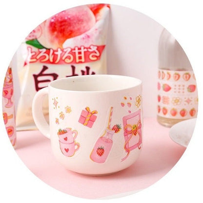 Kawaii Strawberry Washi Tape Roll featuring cute strawberry-themed designs for party decorations and craft projects, displayed next to a white mug with matching strawberry illustrations.