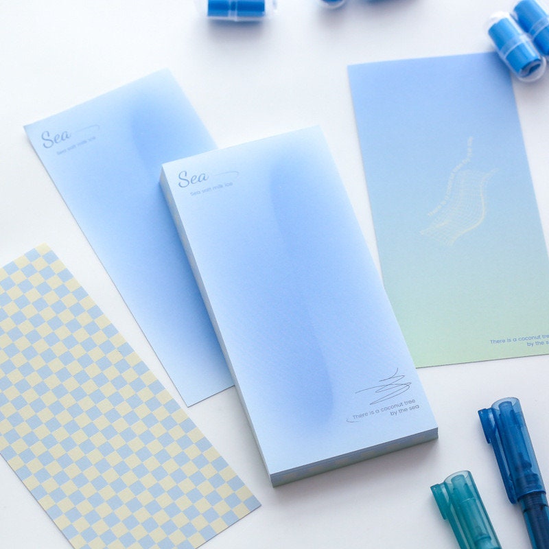 Dreamy Island Notepad Set - 90 Sticky Notes with ombre blue and green designs, pastel checkered pattern, surrounded by blue pens and accessories.