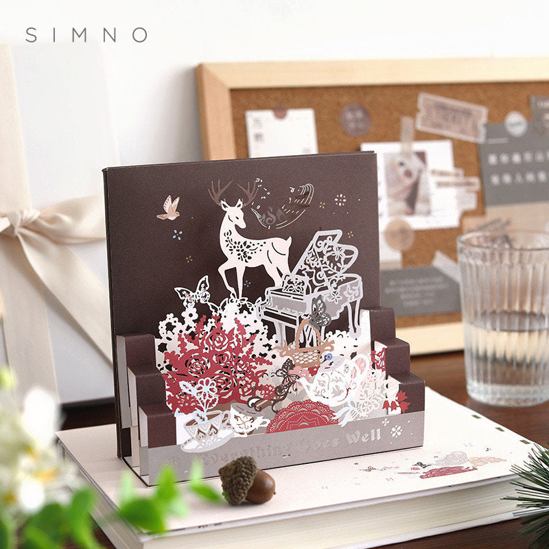 Starlight Studio Pop Up 3D Greeting Card featuring intricate cut-out designs of flowers, a deer, and a piano, set against a dark background, perfect for special occasions and stationery enthusiasts.