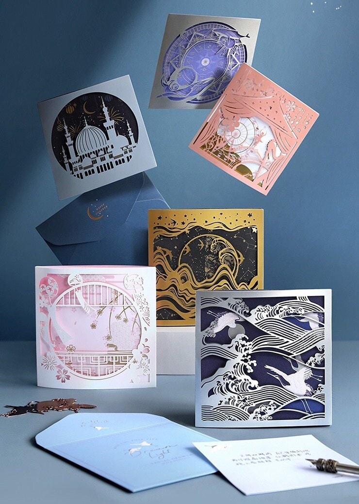 3D Starlight Studio Pop Up Card for All Occasions featuring intricate designs of celestial scenes, architectural landmarks, and nature-inspired patterns in various colors including blue, pink, gold, and silver. Suitable for birthdays, anniversaries, and celebrations.