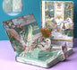 Silver's Will Hard Cover Journal with Metal Bookmark featuring an elegant, ornate design of birds, fairies, and intricate gold accents on a green background.