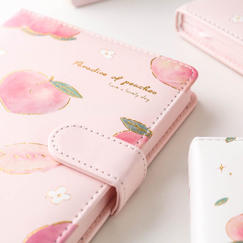 Pink A5 magnetic peach leather planner with 228 pages, featuring kawaii peach designs and "Paradise of peaches" text.