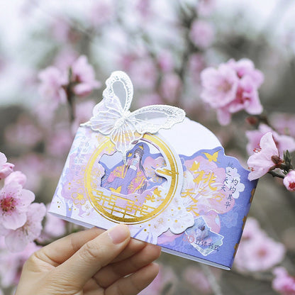 Peach Tree Elf Leather Planner with Butterfly Bookmark in hand, featuring kawaii style with pink flowers in the background.