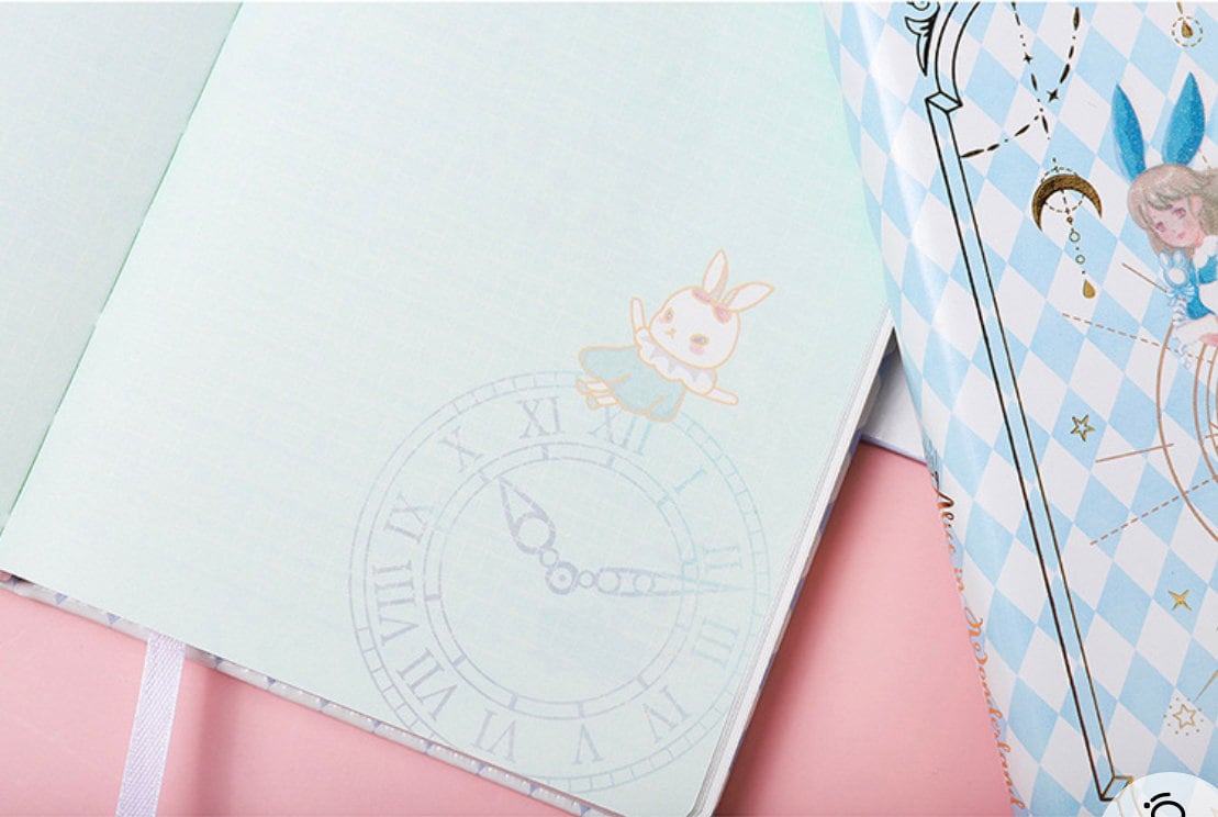 Alice Dream Journal with gold foil leather cover, featuring an illustration of a cute bunny on a clock and an Alice in Wonderland theme.