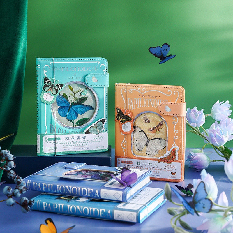 Butterfly leather notebook with 3D pages and bookmark in aquamarine blue and peach color options, featuring detailed butterfly designs and floral decorations, ideal for stationery enthusiasts and nature lovers in kawaii style.