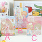 Fashion Macaron Girl Notebook with Bookmark and Buckle in kawaii style, available in three designs: blonde girl in yellow dress (A), blond girl in pink dress holding a bunny (B), and blond girl with doll (C).