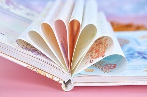 Cherry Blossom Girl Magnetic Buckle Hardcover Notebook with colorful design pages and delicate illustrations, laid open showcasing its unique artwork and high-quality paper.