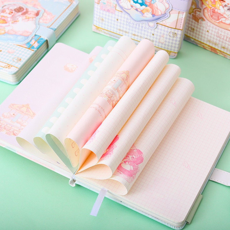 Pink Lolita Leather Journal with Magnetic Buckle featuring pastel printed pages, kawaii-themed illustrations, and grid layout on a pastel green background.