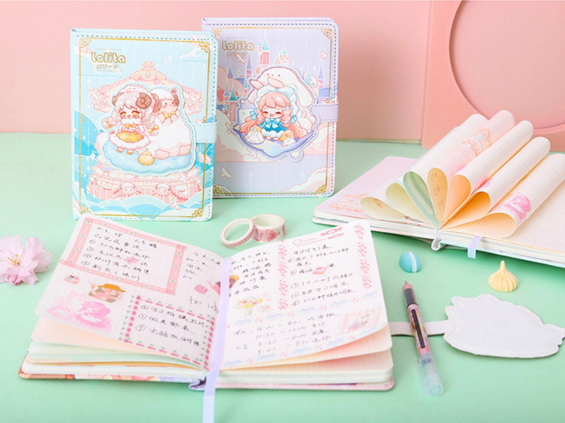 Pink Lolita Leather Journal with Magnetic Buckle on pastel-themed desk. Featuring cute kawaii illustrations, open pages with writing, decorative tapes, a pen, and a flower embellishment. Ideal for note-taking, journaling, or as a kawaii stationery gift.