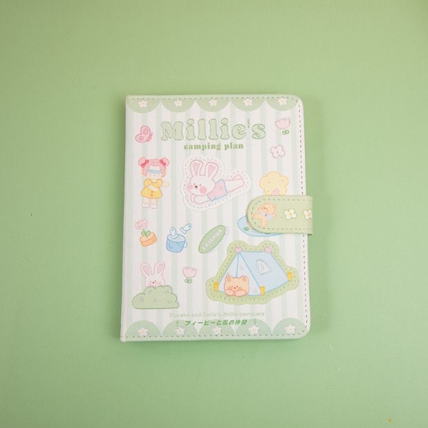 Millie's Leather Camping Journal with colorful pages featuring adorable kawaii camping-themed designs on the cover, including bunnies, trees, and tents.