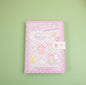 Millie's Leather Camping Journal with colorful pages, pastel pink cover featuring cute kawaii camping illustrations, secure clasp, perfect for kids and journaling enthusiasts.