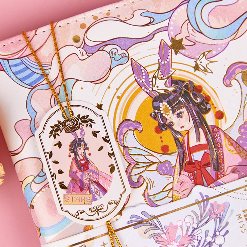 Star Beauty Leather Journal with Metal Bookmark in kawaii style featuring an intricate design of a girl with flowing hair, adorned with celestial and floral motifs and accented with gold embellishments.